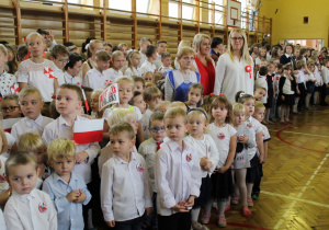 Przedszkolaki śpiewają hymn narodowy na stojąco.